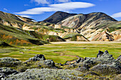 Flusslauf und Tal umgeben von farbigen Bergen und Lavafeldern, Landmannalaugar, Hochland, Südisland, Island, Europa