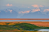 Blick nahe Kirkjubaejarklaustur über Fluss Skeidará auf Berge des Vatnjökull-Gletschermassivs bei Sonnenuntergang, Südisland, Island, Europa