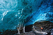 Man with ice axe in blue ice cave below Vatnajokull glacier,  Breidamerkursandur between Skaftafell National Park und Hofn, East Iceland, Iceland, Europe