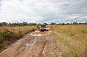 Geländewagen fährt auf Piste durch Wasserpfütze, Kazuma-Pan-Nationalpark, Livingstone, Simbabwe