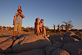 Family looking at view at sunset, Kubu Island, Makgadikgadi Pans National Park, Botswana