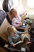 Zwei Jungen lesen Sicherheitshinweise in einem Flugzeug, München, Bayern, Deutschland