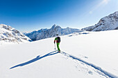 skier in deep powder snow, Zugspitze, overlooking Reintal Valley and Hochwanner, Upper Bavaria, Germany