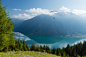 Paraglider starting off from Zwoelferkopf above Lake Achensee, overlooking Rofan mountains, Pertisau, Tirol, Austria