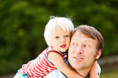 two-year-old girl on her father's back, Speyer, Rheinland-Pfalz, Germany