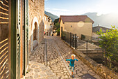 Junge, 4 Jahre alt, rennt die Gasse entlang, romantisches Bergdorf, Serra de Tramantura, Gasse, MR, Biniaraix, Mallorca, Spanien