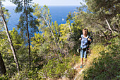 young woman hiking, view across the Mediterranean Sea, MR, Port de Soller, Serra de Tramuntana, Majorca, Balearic Islands, Spain, Europe
