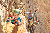 Mädchen klettert am Felsen, Serra de Tramuntana, Port de Soller, Mallorca, Balearen, Spanien, Europa
