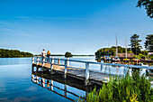 Couple on a pier at lake Ploen, Bosau, Holstein Switzerland, Ostholstein, Schleswig-Holstein, Germany