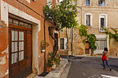 Frau spaziert durch einer Gasse, Saturnin-les-Apt, Dorf bei Apt, Luberon-Gebirge, Luberon, Naturpark, Vaucluse, Provence, Frankreich, Europa