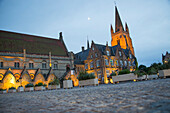 Pflastersteine am Marktplatz mit angeleuchtetem Rathaus und Kirche in der Dämmerung, Nieuwpoort, Flandern, Belgien, Europa