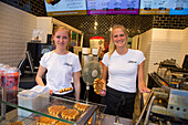 Two young women selling delicious Belgian waffles at Chez Albert bakery and waffle shop in the Old Town, Bruges (Brugge), Flemish Region, Belgium