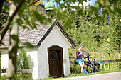 Junge Fahrradfahrerin macht eine Pause um eine Karte zu lesen, Tannheimer Tal, Tirol, Österreich