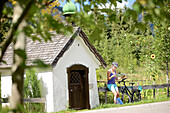 Young female cyclist having a break and reading a map, Tannheimer Tal, Tyrol, Austria