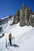 Woman back-country skiing standing at Scharnitzsattel and removing skins, Scharnitzsattel, Lechtal Alps, Tyrol, Austria