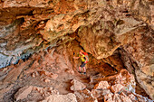 Woman hiking Selvaggio Blu through cave, Selvaggio Blu, National Park of the Bay of Orosei and Gennargentu, Sardinia, Italy