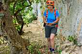 Frau wandert am Selvaggio Blu mit GPS-Gerät in der Hand, Selvaggio Blu, Nationalpark Golfo di Orosei e del Gennargentu, Sardinien, Italien