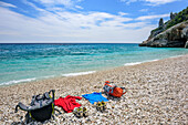Rucksäcke und Kleidung liegen am Strand Cala Sisine am Mittelmeer, Cala Sisine, Selvaggio Blu, Nationalpark Golfo di Orosei e del Gennargentu, Sardinien, Italien