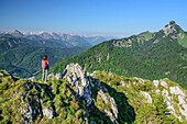 Frau steht am Leonhardstein und blickt auf Rossstein und Buchstein, Leonhardstein, Bayerische Alpen, Oberbayern, Bayern, Deutschland