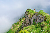 Woman hiking over ridge of molasse conglomerate, Nagelfluh range, Allgaeu Alps, Allgaeu, Svabia, Bavaria, Germany