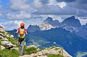 Woman hiking towards Marmolada, Rotwand, Rosengarten, UNESCO world heritage Dolomites, Dolomites, Trentino, Italy
