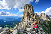 Frau sitzt auf Felsgipfel und geniesst Aussicht, Klettersteig Masare, Masare, Rotwand, Rosengarten, UNESCO Weltnaturerbe Dolomiten, Dolomiten, Trentino, Italien