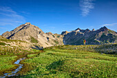 Woman hiking with Vorderseespitze and Feuerspitze in background, Lechtal Alps, Tyrol, Austria