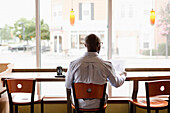 Black man reading paperwork in coffee shop, Norfolk, Virginia, USA