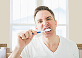 Caucasian brushing his teeth in bathroom, Lehi, Utah, USA