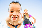 Low angle view of Caucasian children smiling outdoors, Lehi, Utah, USA