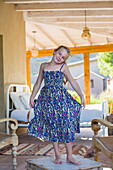 Caucasian girl displaying dress in living room, Santa Fe, New Mexico, USA