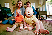 Caucasian mothers and babies sitting on living room floor, C1