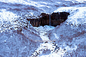 Waterfall and river in snowy landscape, Svartifoss, Sudhurland, Iceland, C1