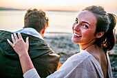 Caucasian woman relaxing with boyfriend on beach, Seattle, Washington, United States