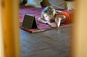 Caucasian girl watching digital tablet on floor, Santa Fe, NewMexico, USA