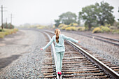 Caucasian girl balancing on train tracks, Santa Fe, New Mexico, USA