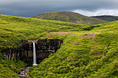 Waterfall in rolling hills in remote landscape, Skaftafell, Iceland, Iceland