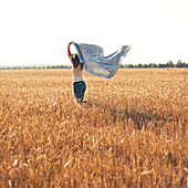 Caucasian woman carrying blanket in rural field, Nizhniy Tagil, Sverdlovsk region, Russia