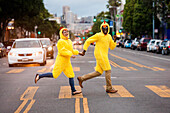Couple in chicken costumes crossing city street, San Francisco, California, United States
