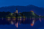 Village church and buildings reflected in still lake at night, Bled, Upper Carniola, Slovenia, Bled, Upper Carniola, Slovenia