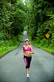 Caucasian woman running on remote road, Bainbridge Island, Wa, USA