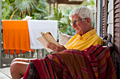 Caucasian man reading on porch, Florida Keys, Florida, USA