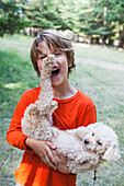 Caucasian boy playing with puppy outdoors, Hope, Idaho, USA