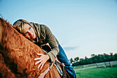 Caucasian woman riding horse on ranch, C1