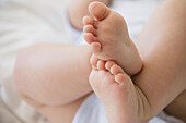Close up of feet of mixed race baby, C1