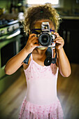 Mixed race girl photographing with camera, C1