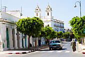 Morocco, Asilah, street scene, Saint Bartholomew church in backgound