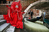 Italy, carnival of Venice, mask in front of a gondola