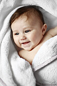 Portrait of a 4 months old baby naked in a towel