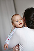 Mother holding in her arms her baby girl